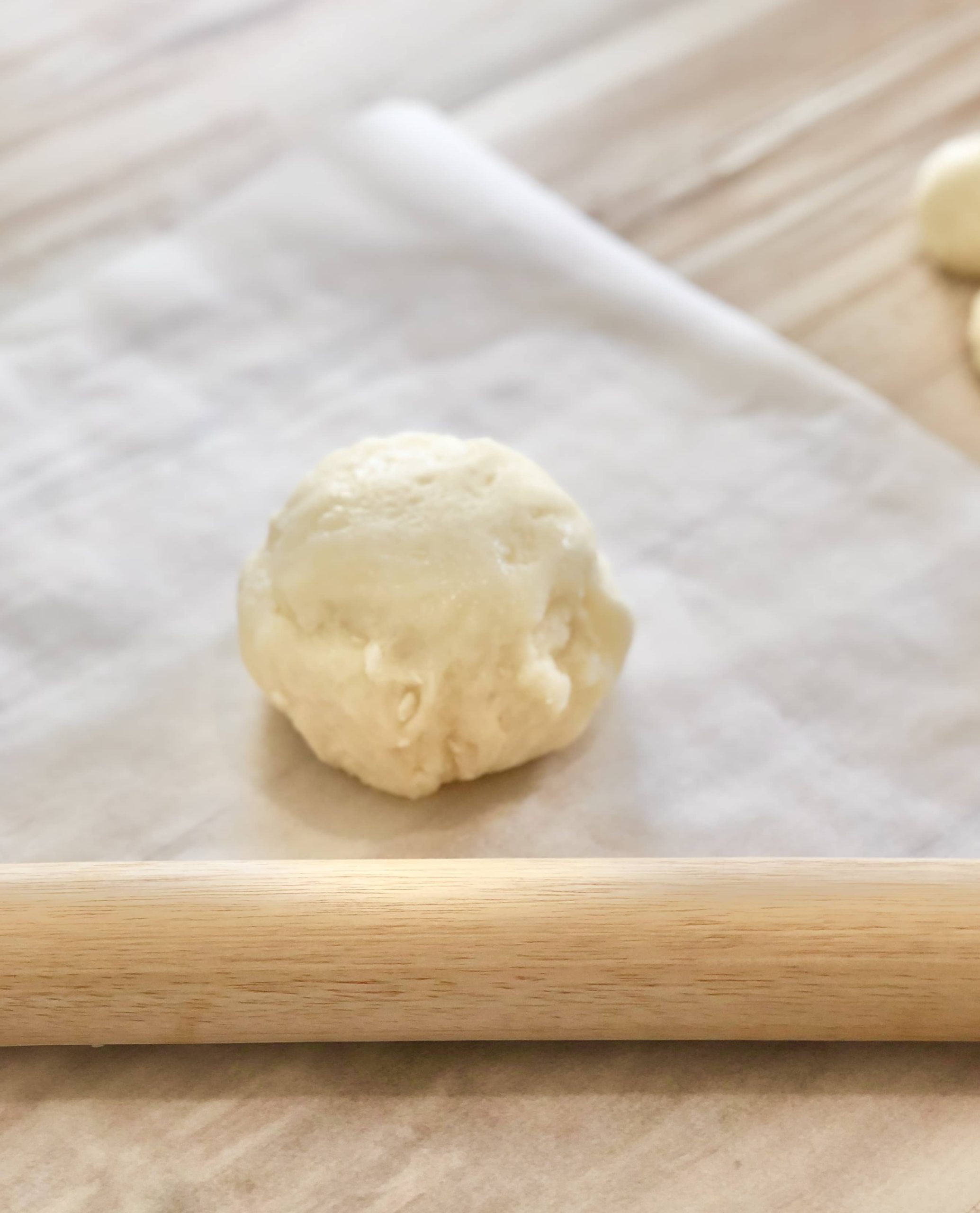 boule de pâte sur une feuille de papier cuisson